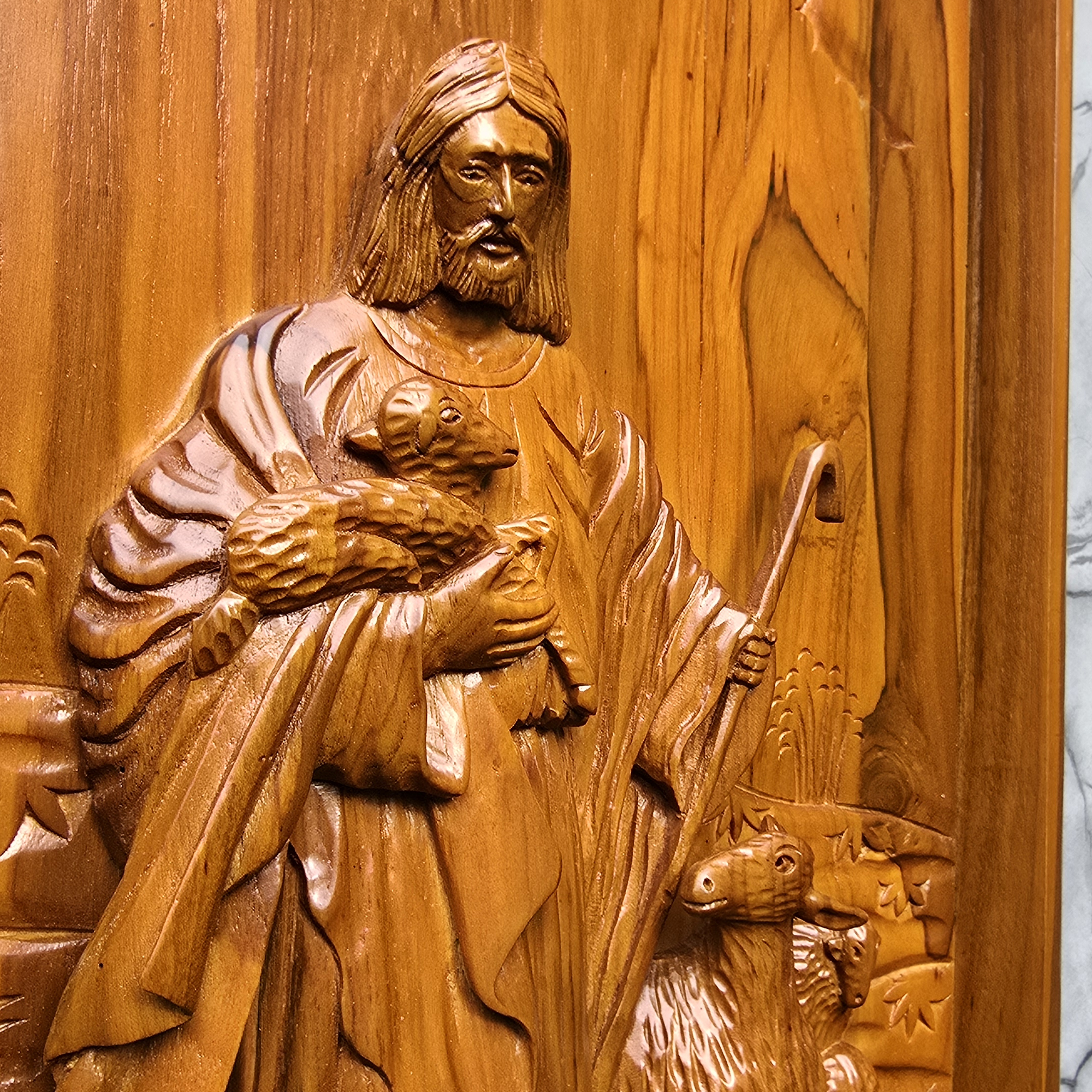 Wooden carving of a shepherd with sheep on a wooden panel