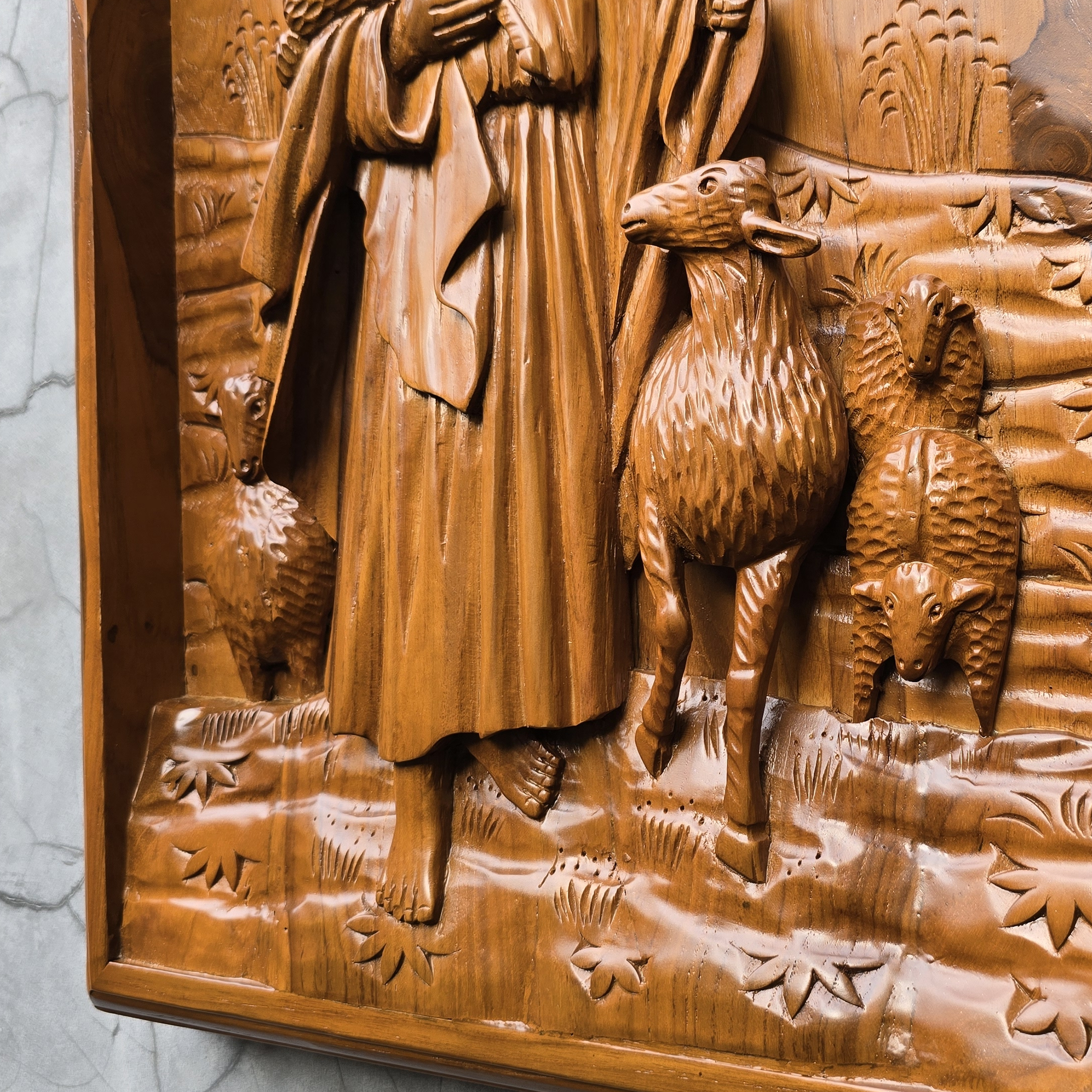 Wooden relief sculpture of a shepherd with two sheep