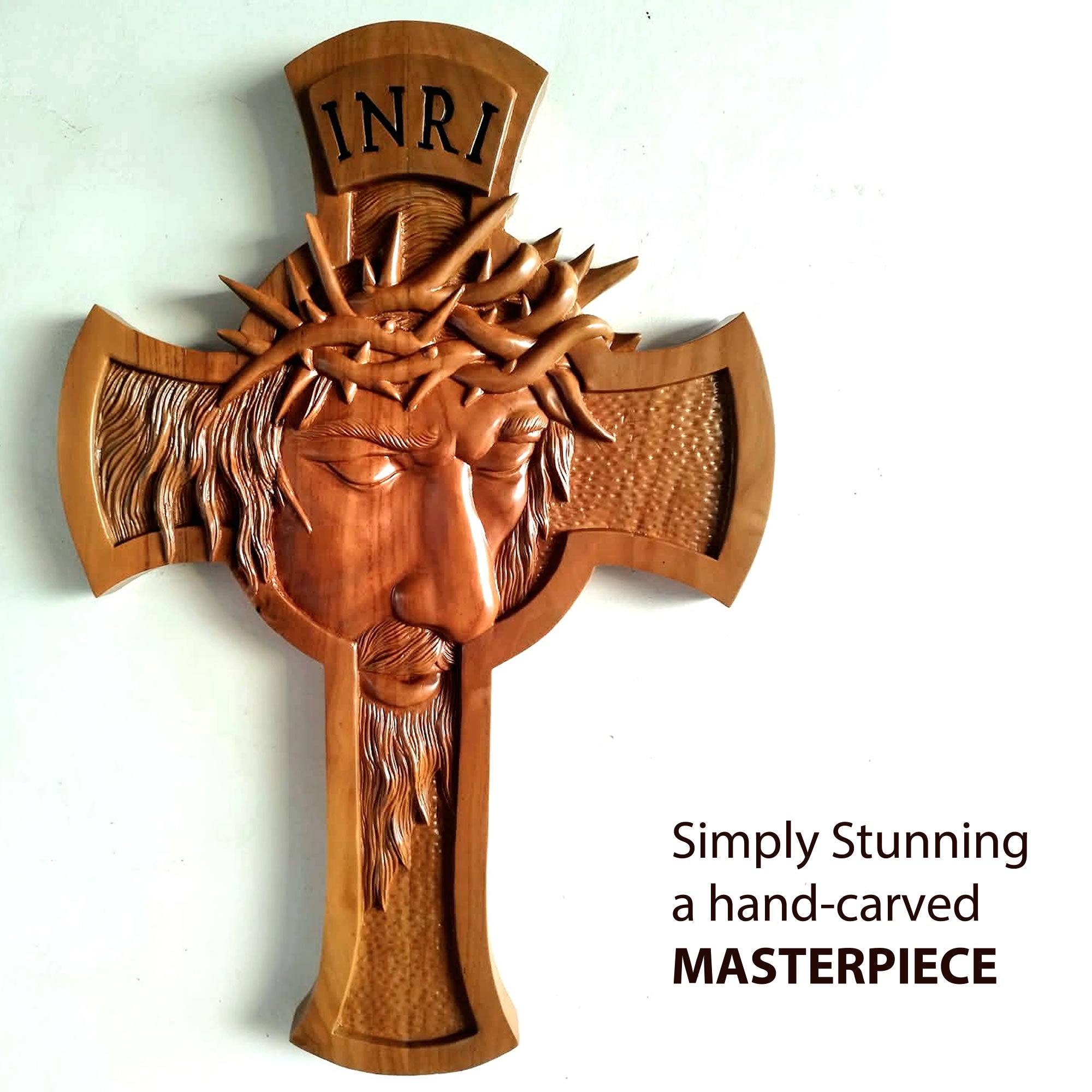 A hand-carved wooden cross featuring a detailed relief of Jesus Christ's face with a crown of thorns, with 'INRI' carved at the top. The image is set against a plain white background with a text overlay on the bottom right.