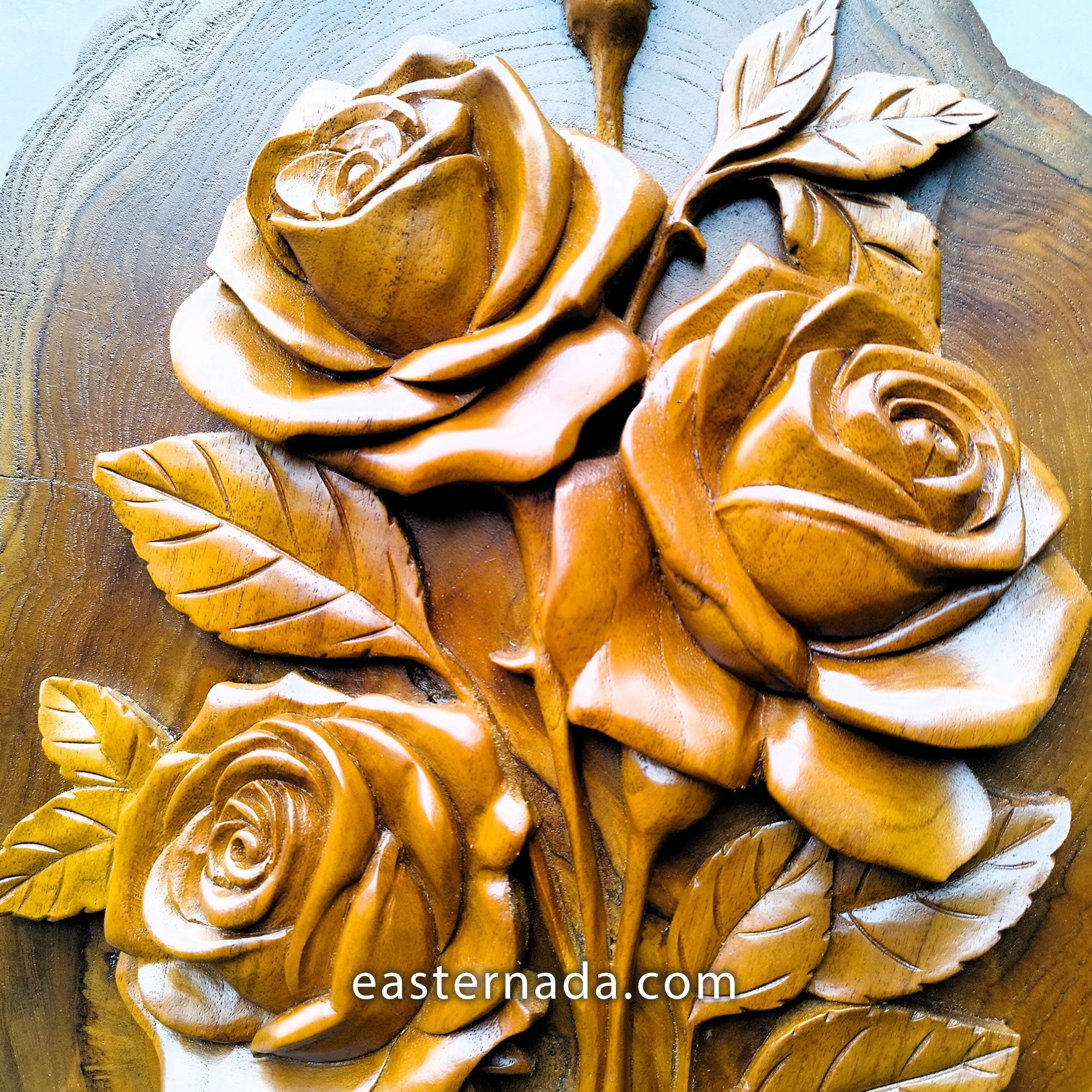 close up of hand-carved teakwood roses sculpture highlighting the 3D relief carving and the thickness of the solid wood on a gallery wall