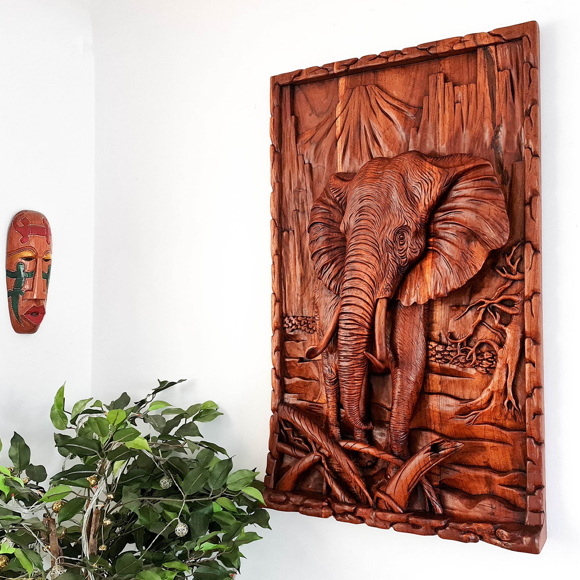 This stunning hand-carved African elephant is undoubtedly a masterpiece. Carved out of solid teakwood, the carver has captured the raw majestic nature of the African elephant in its environment. A wood art that will adorn the walls and become a focal point in any room.