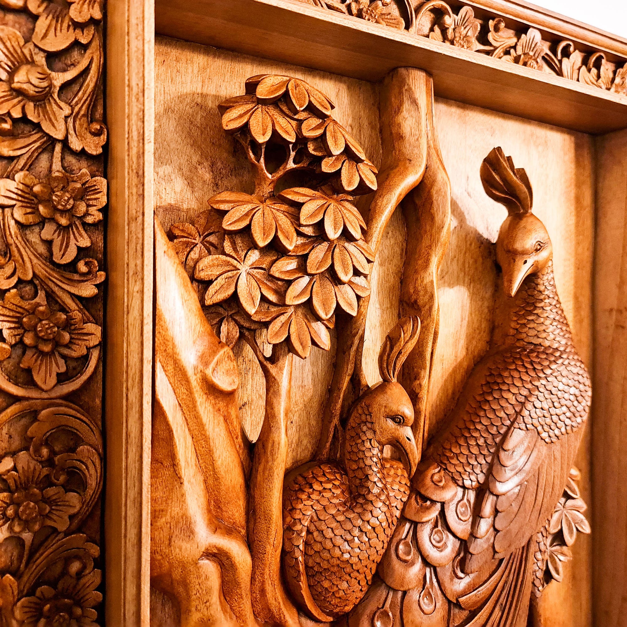 This is a stunning masterpiece. Intricate detailed hand carved Peacock birds out of Teak Wood. With decorative frame to match this will be the focal point in any room. Only one piece carved and its an exclusive and unique collection. A Perfect Gift - Easternada