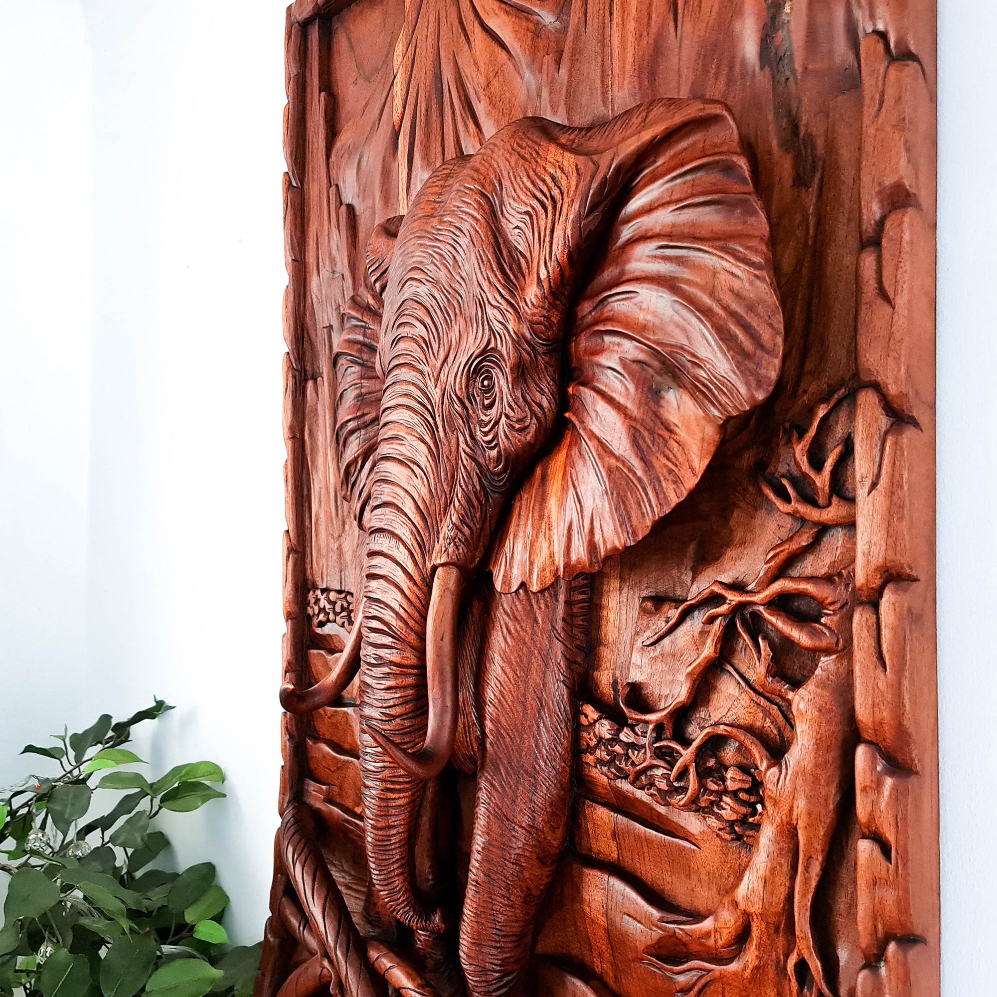 This stunning hand-carved African elephant is undoubtedly a masterpiece. Carved out of solid teakwood, the carver has captured the raw majestic nature of the African elephant in its environment. A wood art that will adorn the walls and become a focal point in any room.