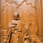 Wooden carving of a shepherd with sheep and a staff