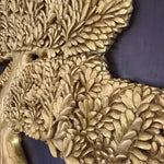 Close-up of hand-painted gold calligraphy-style branches on a 3D teakwood carving; showcasing high-relief artisan detail