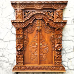 Frontal view of a hand-carved solid teakwood Gebyok wall art with doors closed, showing intricate Javanese floral carvings