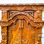 Close-up detail of the traditional Javanese carvings on the miniature Gebyok doors, showcasing the fine artisan craftsmanship