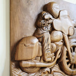 Close-up of the intricately chiseled engine details and exhaust pipes on the wooden motorcycle sculpture