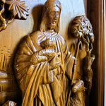 Detailed closeup of solid teak wood carving showing dimensional relief details of Jesus Christ as the sacred shepherd, hand-crafted wall sculpture.