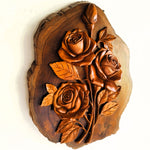 Side view of hand-carved teakwood roses sculpture highlighting the 3D relief carving and the thickness of the solid wood on a gallery wall
