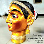 Hand-carved solid teakwood ethnic woman face sculpture with gold finish and silver jewelry embellishments.