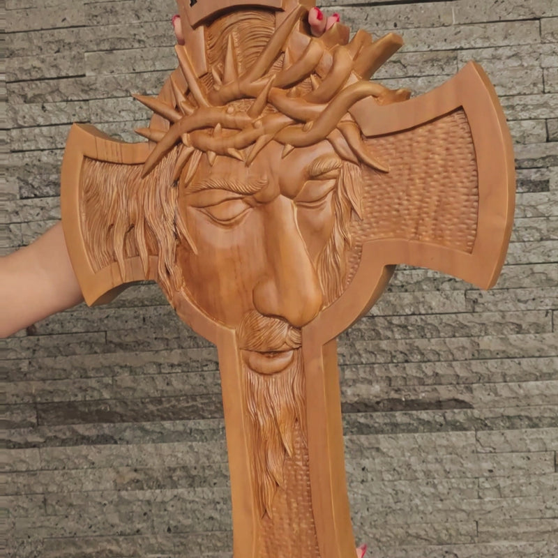 Detailed close-up of the carved crown of thorns and facial expression on a solid teakwood Jesus crucifix
