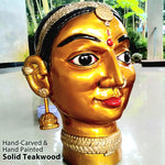Hand-carved solid teakwood ethnic woman face sculpture with gold finish and silver jewelry embellishments.